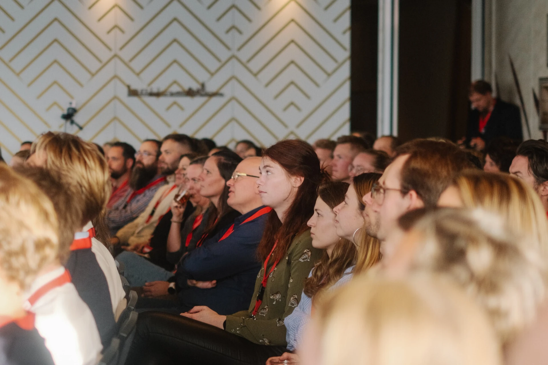 Groep mensen die aandachtig naar een presentatie luisteren tijdens de IDTE