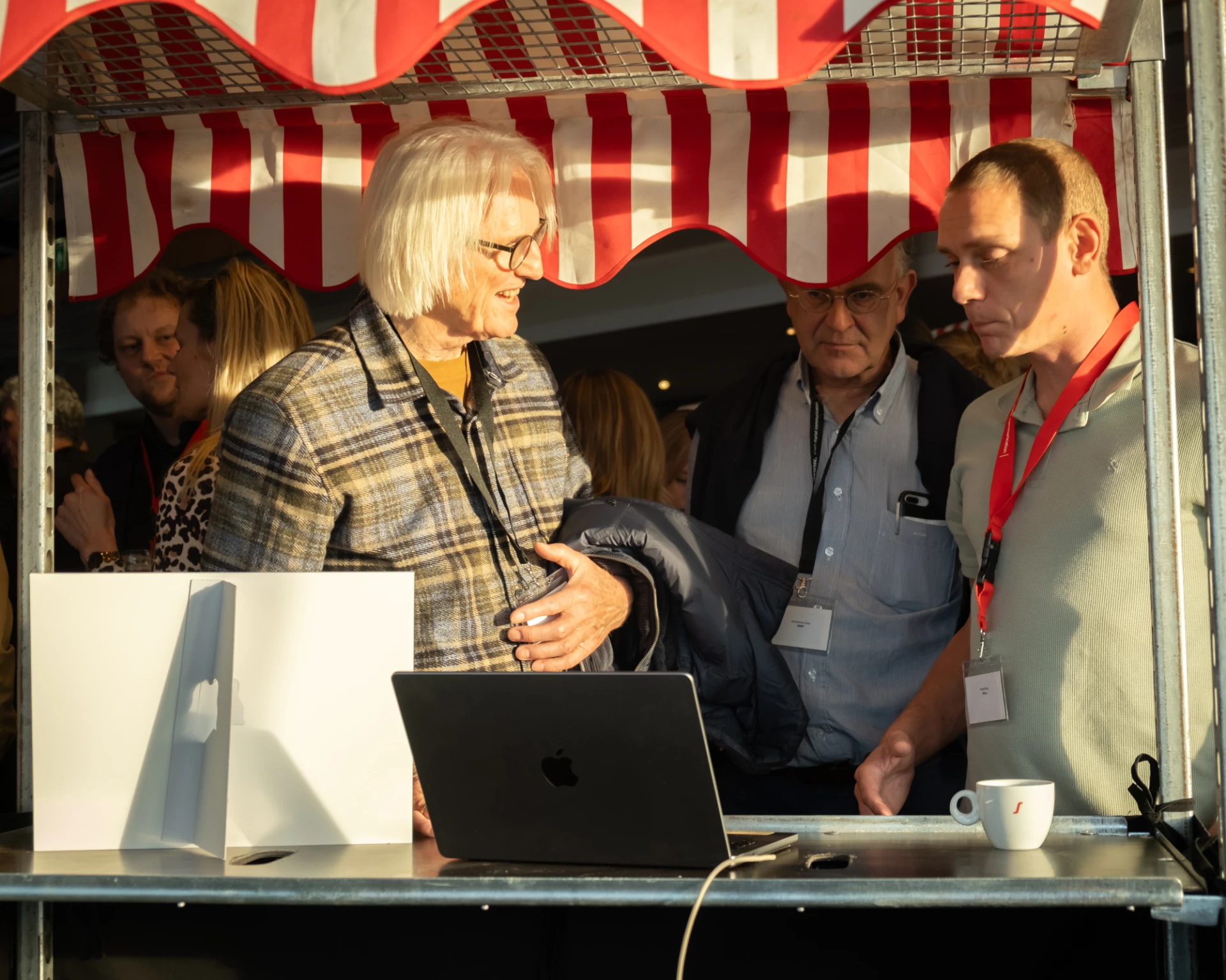 Een groep mensen staat bij een kraam op de informatiemarkt van iWink Digital Trend Event