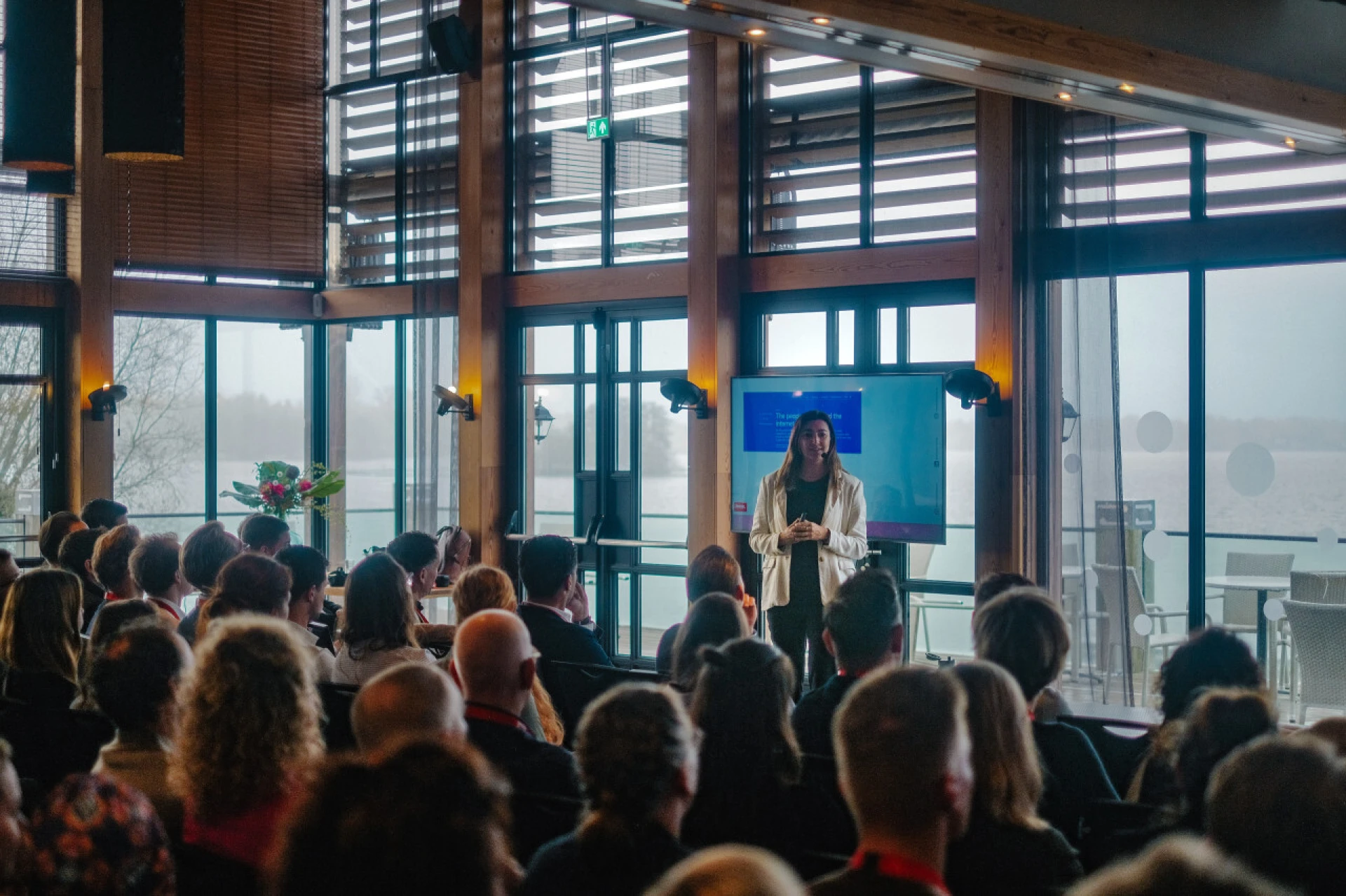 Een presentatie wordt gegeven aan een aandachtig publiek in een moderne conferentieruimte.