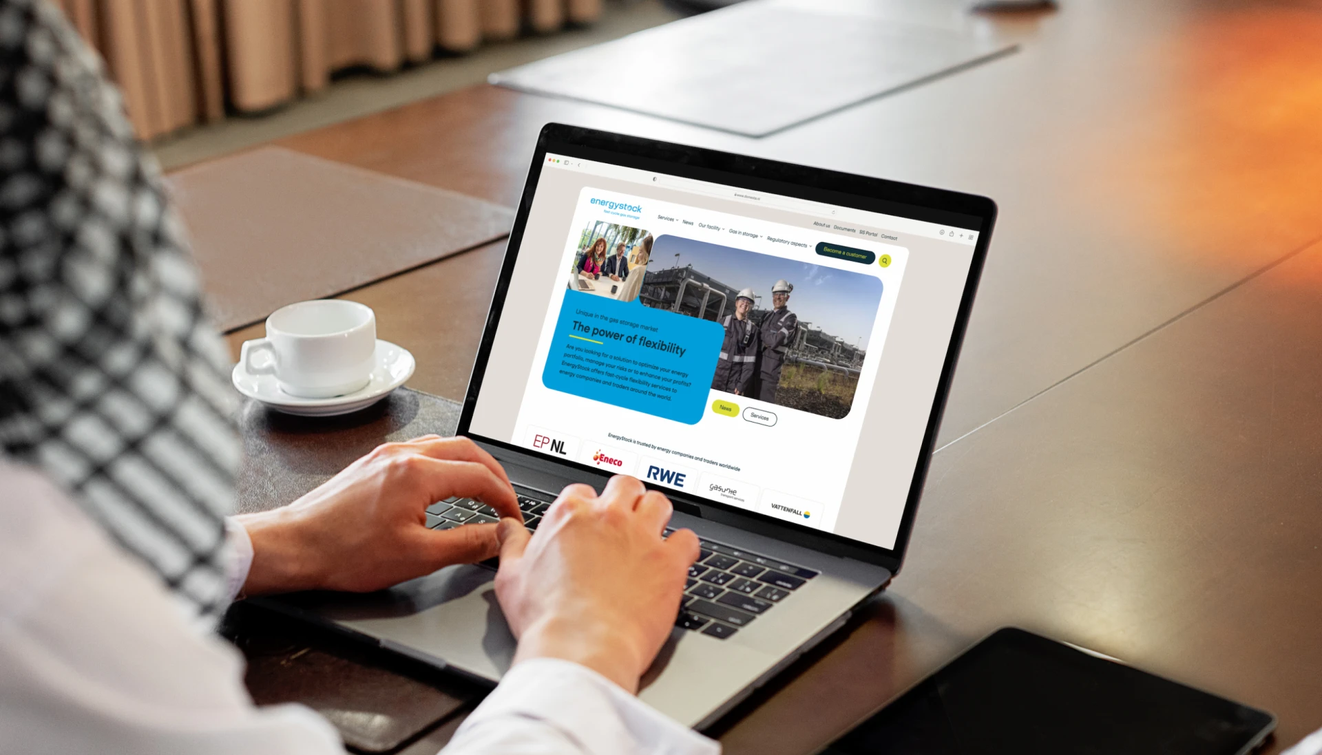 Persoon bekijkt een website op een laptop in een kantooromgeving.