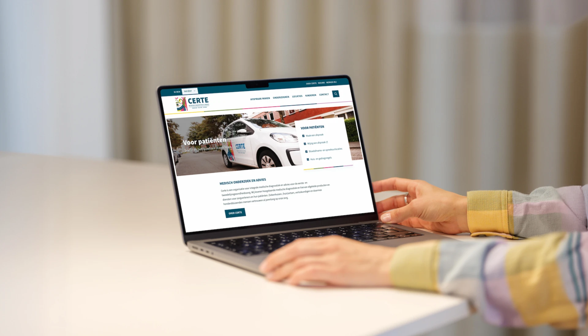Een persoon bekijkt een website op een laptop.