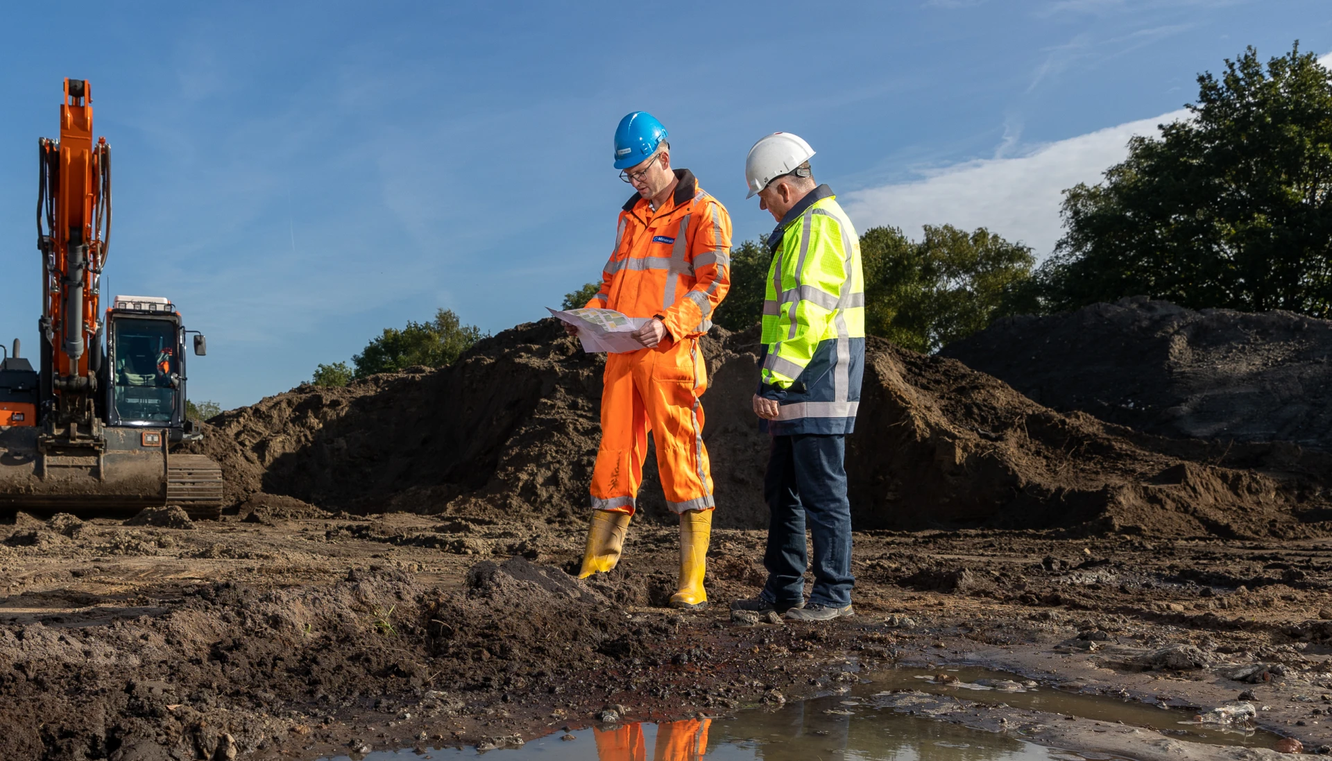 Twee bouwvakkers overleggen op een bouwplaats.