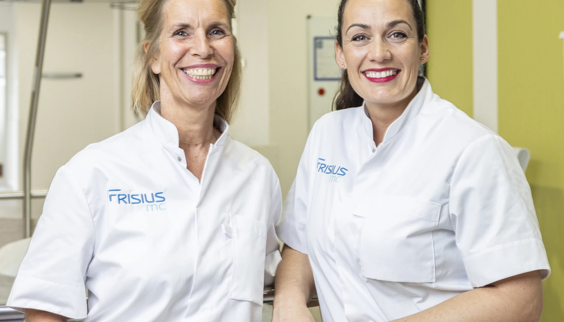 Twee lachende tandheelkundige professionals in een kliniek.
