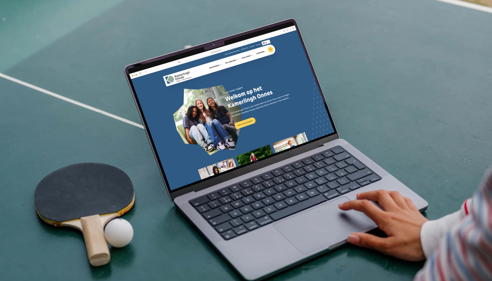 Een laptop op een tafeltennistafel naast een batje en bal.