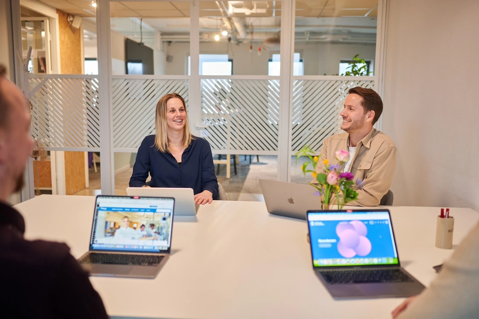Mensen in een vergaderruimte met laptops.