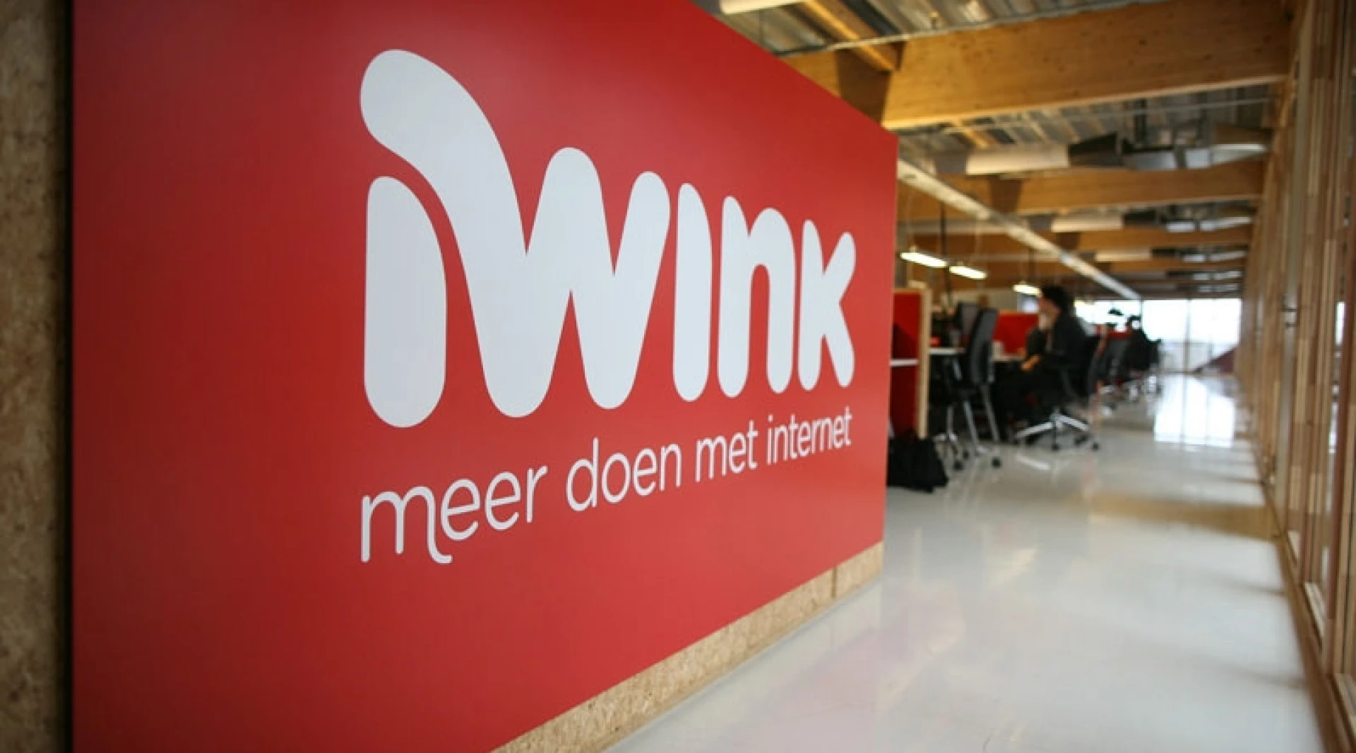 Een kantoorruimte met een groot bord met de tekst "iWink, meer doen met internet".
