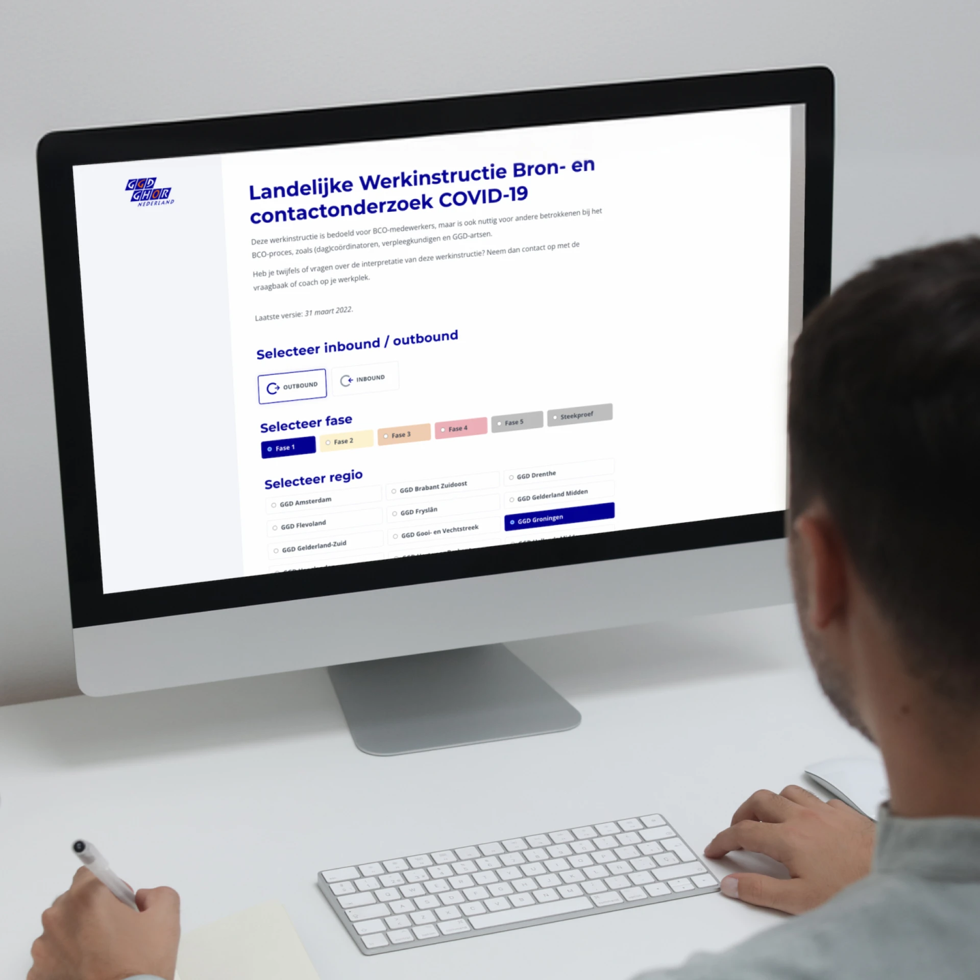 Een persoon werkt aan een computer met een COVID-19 gerelateerd formulier op het scherm.